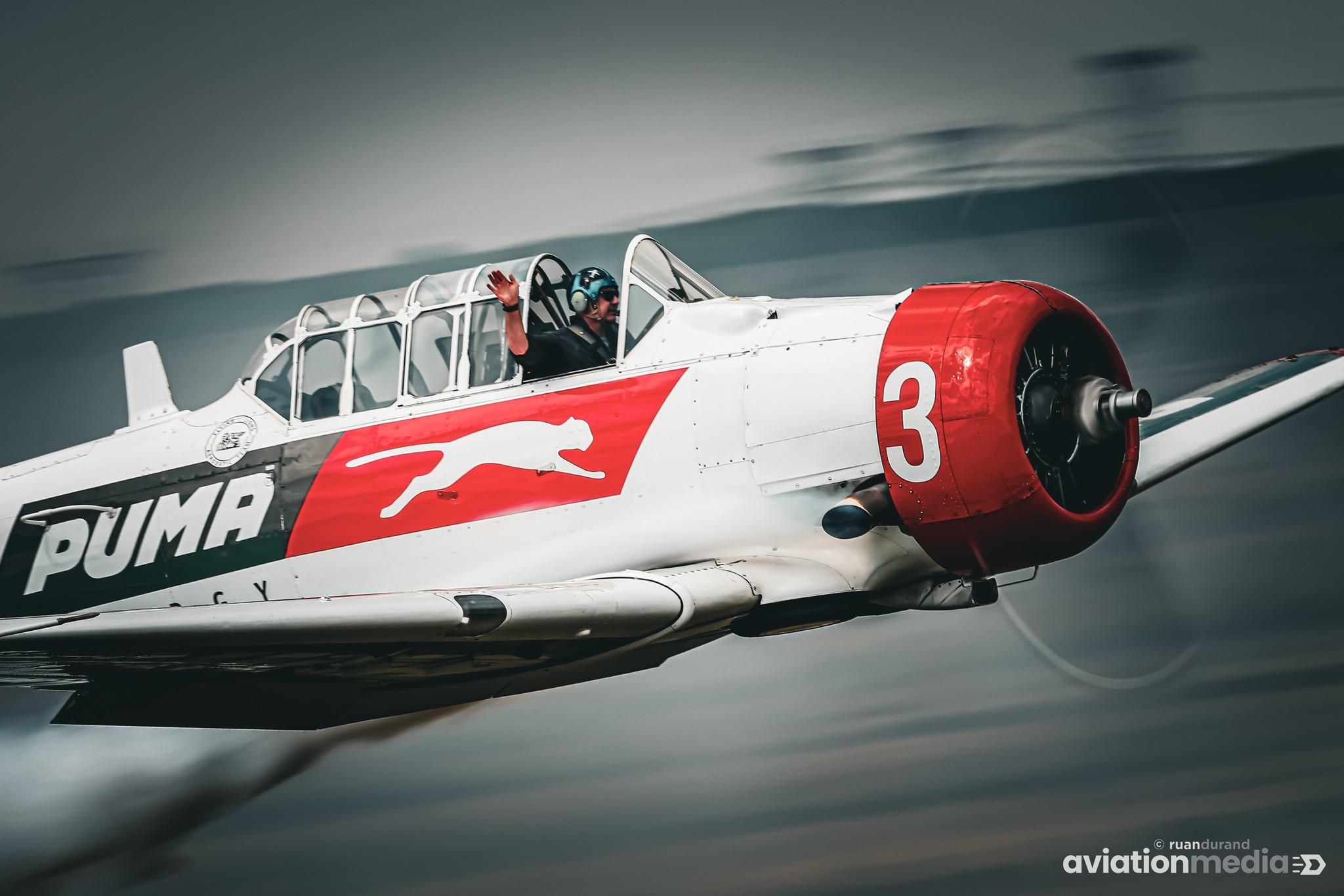 Aerobatic warbird trailing smoke through cloud